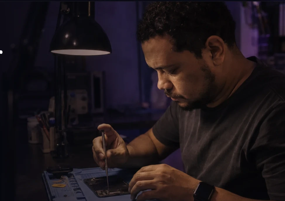Técnico trabalhando em uma bancada de reparo de celular